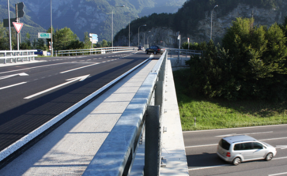 Blick vom Geländer der Brücke. Links im Bild ist die Brücke zu sehen, rechts im Bild die Autobahn unterhalb der Brücke